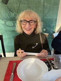 a woman with glasses sitting at a table